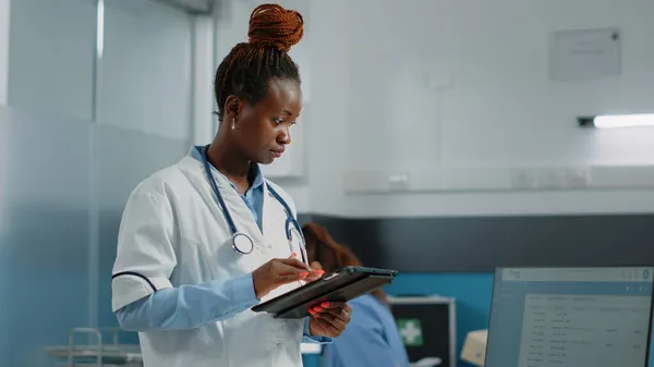 Médecin regardant écran tablette pour le système de santé — Photo