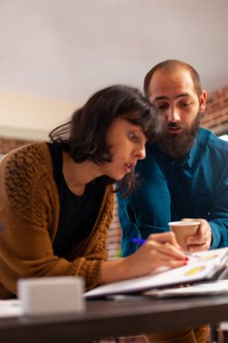 İş kadını, şirket istatistik belgelerini müdürle birlikte analiz ederek pazarlama stratejisini açıklıyor