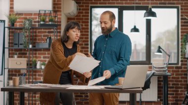 Öfkeli kadın, erkeklerle kavga ettikten sonra kağıtları havaya fırlatıyor.