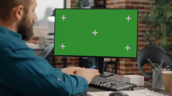 Zbliżenie człowiek działa na poziome zielony ekran w biurko — Zdjęcie stockowe