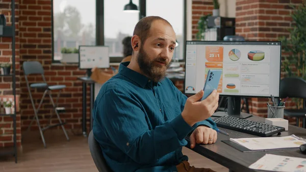 Biznes człowiek trzyma smartfona do rozmowy na wideo rozmowy — Zdjęcie stockowe