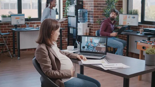 Funcionário grávida usando videochamada para conversar com o gerente — Fotografia de Stock