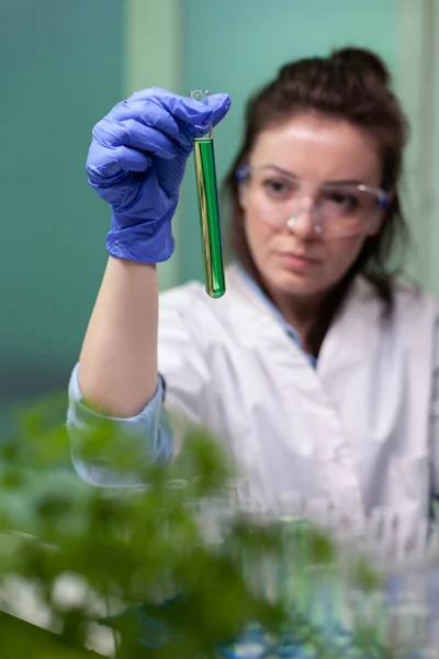 Retrato de médico bioquímico mujer sosteniendo tubo de ensayo médico con líquido verde — Foto de Stock