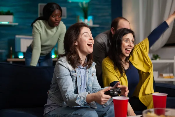 ऑनलाइन स्पर्धा जिंकून गेमिंग कंट्रोलर वापरून व्हिडिओ गेम खेळत आनंदी उत्साहित महिला — स्टॉक फोटो, इमेज