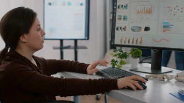 Felç olmuş finansal uzman tekerlekli sandalyede oturmuş ekonomi istatistiklerini analiz ediyor.