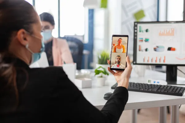 Zakenvrouw houdt smartphone bespreken met externe vrienden — Stockfoto