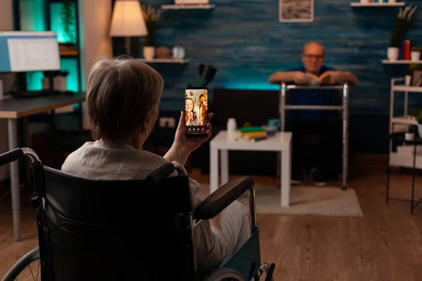 Starší žena držící smartphone pro video hovor — Stock fotografie