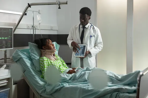 Afrikalı Amerikalı doktor hasta kadına radyografi uzmanlığını açıklıyor. — Stok fotoğraf