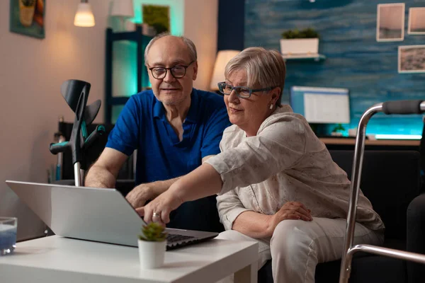 Oudere paar op zoek naar moderne laptop op tafel — Stockfoto
