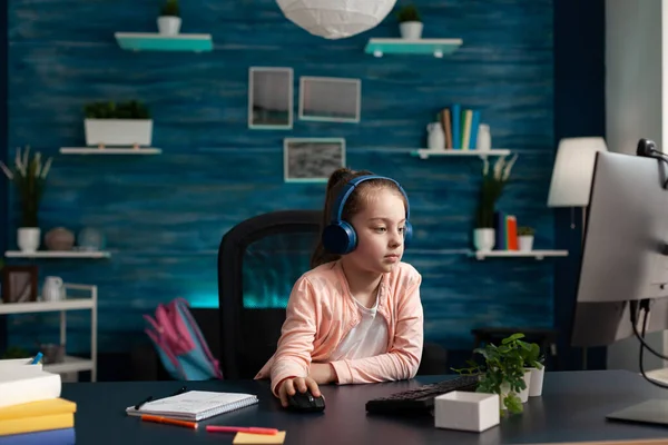 Małe dziecko ze słuchawkami dostosowującymi się do lekcji literatury internetowej — Zdjęcie stockowe