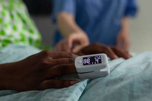Closeup of african american sick patient resting in bed with medical oximeter on finger — Stock Photo, Image