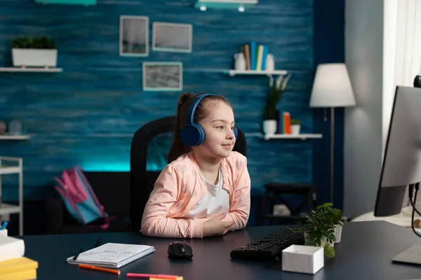 Little schoolkid wearing headset having online literature lesson on computer — Stock Photo, Image