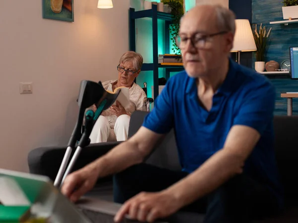 Emekli yaşlı adam evde dizüstü bilgisayarda klavye kullanıyor. — Stok fotoğraf
