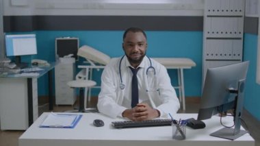 Afro-Amerikan terapist doktor portresi. Masada oturmuş, tıbbi uzmanlık alanında çalışıyor.