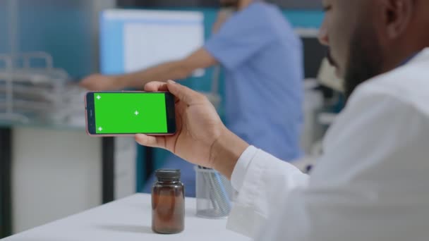 Afrikanische amerikanische Therapeut Arzt hält Attrappe bis Green Screen Chroma Key Smartphone — Stockvideo