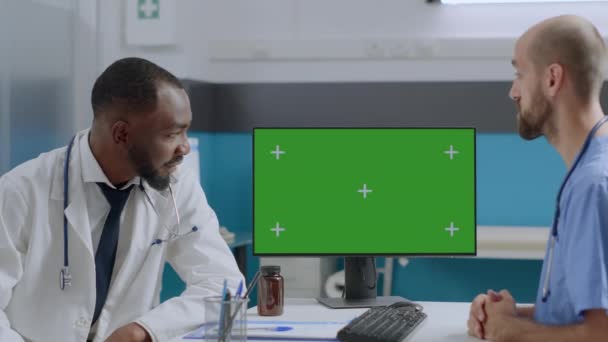 녹색 화면 크로마 키 컴퓨터를 분리 된 디스플레이와 함께 모 밍하고 있는 다중 민족 팀 — 비디오