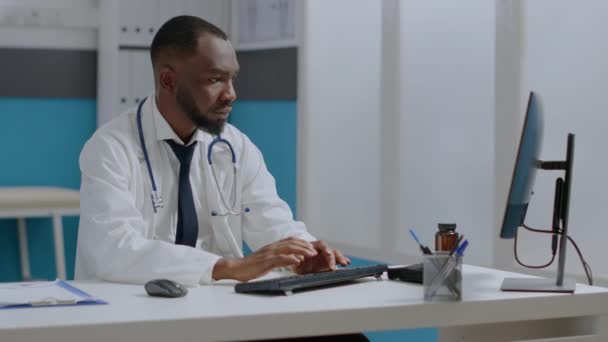 Thérapeute afro-américain médecin vérifier rapport de maladie dactylographier expertise médicale — Video