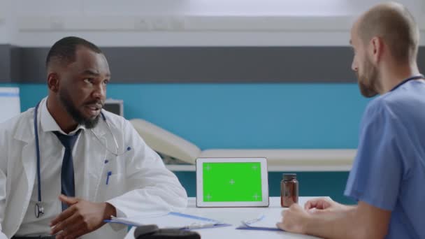 Médecin afro-américain médecin expliquant les symptômes de la maladie à l'homme infirmière — Video