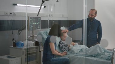 Hastanedeki hasta çocuk, tıbbi muayene sırasında hastalık sonrası iyileşme sürecinde uykuya daldı.