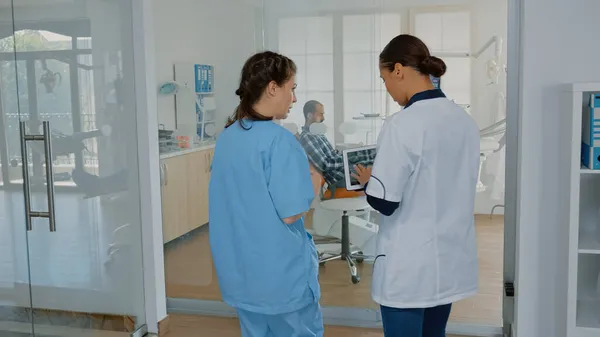 Orthodontic team discussing teethcare with x ray scan — Stock Photo, Image