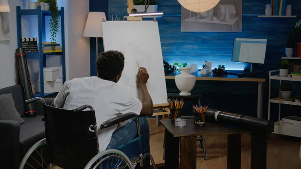 Behinderter afrikanisch-amerikanischer Mann arbeitet an Zeichnung einer Vase — Stockfoto