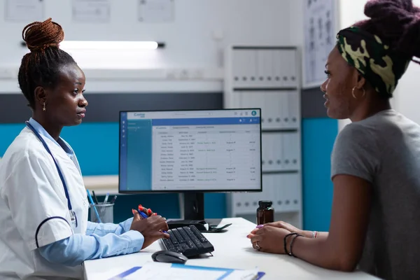 Afrikanisch-amerikanischer Arzt diskutiert mit Patient — Stockfoto