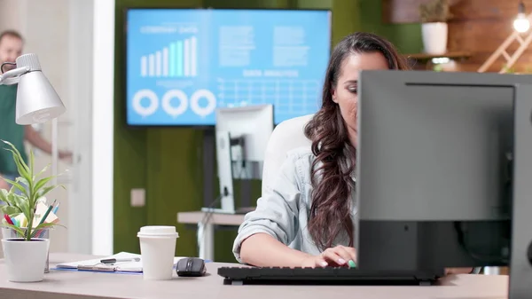 Mujer de negocios sentada en el escritorio escribiendo estrategia de marketing en el teclado de la computadora — Foto de Stock