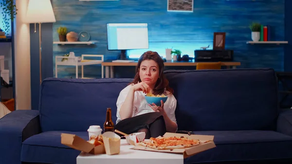 POV för vuxna tittar på TV och äter chips från skål — Stockfoto
