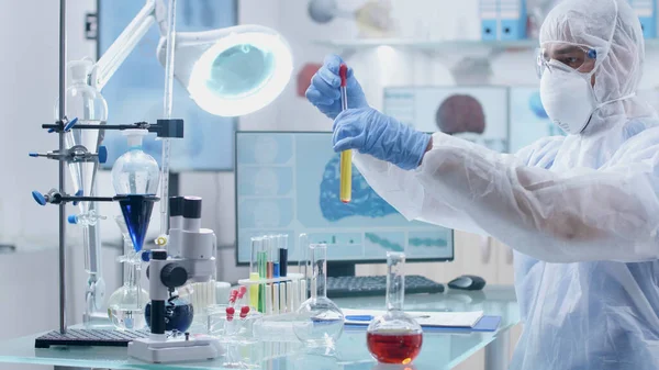 Ученый-микробиолог носит оборудование ppe, работающее в химическом эксперименте — стоковое фото
