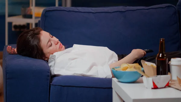 Närbild av sömnig kvinna som ligger på soffan efter att ha ätit — Stockfoto