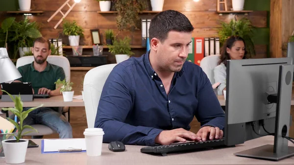 Uomo d'affari di successo seduto alla scrivania digitando strategia di marketing sulla tastiera del computer — Foto Stock