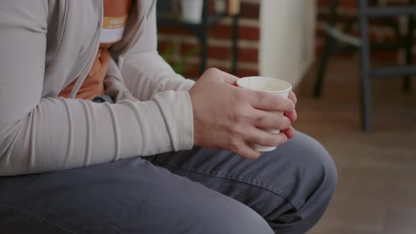 Крупним планом чоловік трясе і п'є чашку кави на сеансі терапії — стокове відео