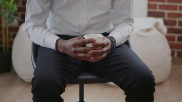 Primer plano del hombre con una taza de café en las manos que asisten a la reunión de aa terapia — Vídeo de stock