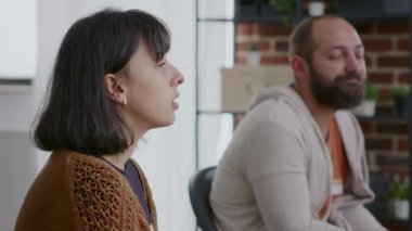 Bir kadın grup terapisinde el sıkışıyor ve bir fincan kahve tutuyor.