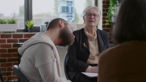 Therapeutin berät und berät Menschen mit psychischen Problemen bei einem Treffen — Stockvideo