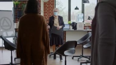 Terapist grup terapi programında insanları selamlıyor. 19 salgın sırasında.