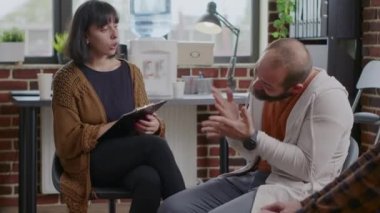 Erkek, A.A. terapi toplantısında bir kadının önünde sinir krizi geçiriyor.