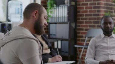 Bağımlılık öyküsünü A.A. rehabilitasyon toplantısındaki bir grup insanla paylaşan üzgün adamı kapatın.