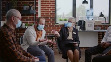 Yüzü maskeli bir kişi A.A. toplantısında grupla öfke kontrolü sorunları paylaşıyor