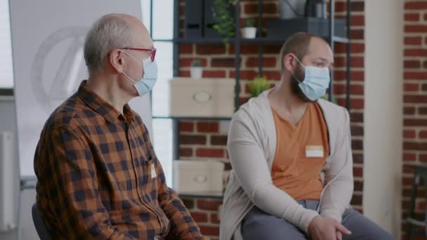 Крупним планом пацієнтів із залежністю, які носять маску для обличчя на засіданні групи АА — стокове відео