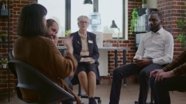 AA grup toplantısında bağımlı insanları dinleyen kadın terapist.