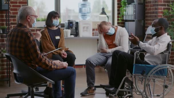 Homme handicapé participant à une réunion de thérapie aa avec des personnes pendant la pandémie de covidé 19 — Video