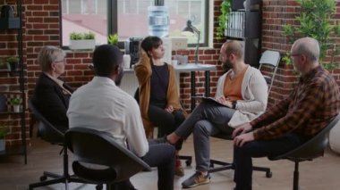 Akıl sağlığı sorunları olan bir kadın A.A. grup terapisindeki insanlarla bozukluk paylaşıyor.