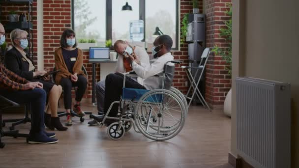 Hombre sentado en silla de ruedas y hablando de adicción en una reunión aa, asistiendo a una sesión de terapia — Vídeo de stock