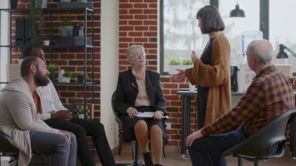 Frau teilt Therapiefortschritte mit Gruppe bei einem Treffen und erhält Applaus — Stockvideo