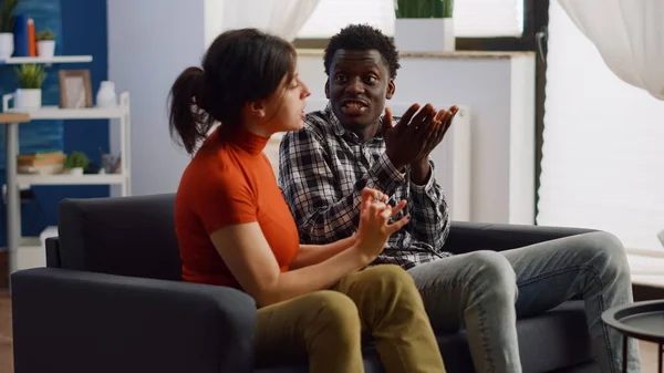 Arga interracial par slåss på vardagsrummet soffa — Stockfoto