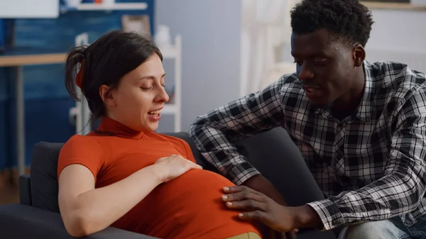 Close-up de casal interracial com gravidez em casa — Fotografia de Stock