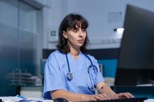 Gesundheitsspezialist arbeitet mit Monitor und Tastatur — Stockfoto