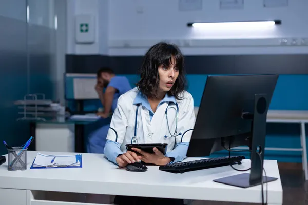 Donna che lavora come medico con tablet digitale e computer — Foto Stock