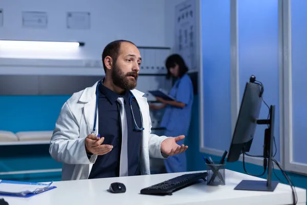 Médico usando videollamada en computadora para comunicación remota —  Fotos de Stock